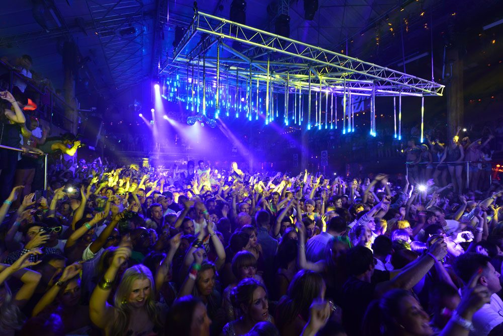 Crowd inside Amnesia Ibiza under blue and yellow lighting