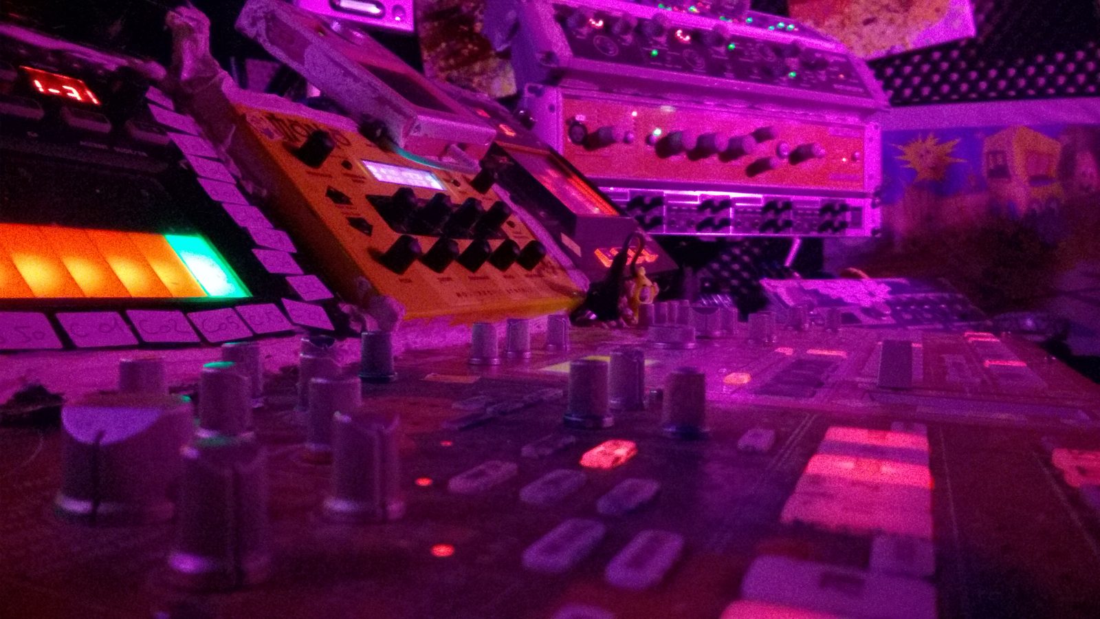 Electronic music studio equipment under magenta lighting
